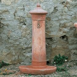 Small Terracotta fountain with water collecting plate. Removable cap. Good thermal insulation. The "grigiolava" version gives it the appearance of a cast artifact.