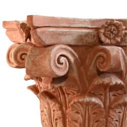 Corinthian capital in terracotta with carved acanthus leaves and lateral volutes