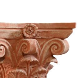 Corinthian capital in terracotta with carved acanthus leaves and lateral volutes