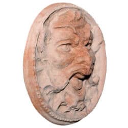 Mascherone circolare in terracotta con volto espressivo scolpito in rilievo decorativo