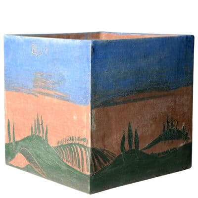 Cubo con cipressi e cielo azzurro. Vaso quadrato per piante. Pezzi unici eseguiti a mano libera: una forma rigida come il cubo in contrapposizione con le morbide colline toscane e l'azzurro del cielo estivo, per oggetti d'arredo unici. Non vi sarà un cubo uguale a un altro, ma soltanto simile perché eseguiti senza alcun disegno, in estemporanea dall’artista, dal quale sono firmati e datati. Realizzabili nelle dimensioni cm 40x40 o cm 45x45, i colori sono resistenti in esterno. Fatti a mano con argilla di Impruneta, resistente al gelo a -30 °C di eccellente durata, la forma rimane inalterata nel tempo.