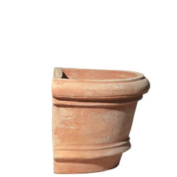 The Shallow wall pot with borders in terracotta, shaped like a half planter with decorative edges. Ideal for climbing plants. Perfect for terraces, gardens, and sidewalks.