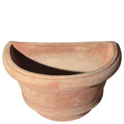 The Shallow wall pot with borders in terracotta, shaped like a half planter with decorative edges. Ideal for climbing plants. Perfect for terraces, gardens, and sidewalks.