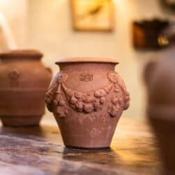 Small festooned jar in Impruneta terracotta with raised decorations and ornamental handles. Ideal as a decorative element or planter for flowers and greenery.