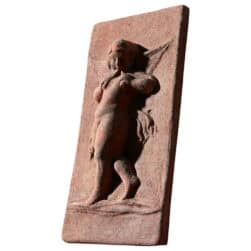 Terracotta relief panel with winged angel holding flutes, Renaissance-style decorative artwork