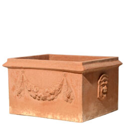 Cassetta due maschere in terracotta, con maschere grottesche e festoni, è ideale per piante e fioriture, unendo tradizione e simbolismo storico.