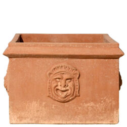 Cassetta due maschere in terracotta, con maschere grottesche e festoni, è ideale per piante e fioriture, unendo tradizione e simbolismo storico.