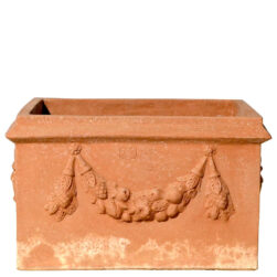 Cassetta due maschere in terracotta, con maschere grottesche e festoni, è ideale per piante e fioriture, unendo tradizione e simbolismo storico.